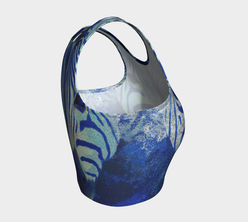 A women's sleeveless, high-neck crop top made from a performance spandex knit fabric. The top is designed with a body-hugging fit and features a striking, symmetrical digital graphic of a zebra's face. The intricate print uses shades of electric blue, cobalt, and navy, contrasted with a shimmering silver glitter effect that outlines the zebra's stripes and features. The psychedelic, futuristic design covers the entire front of the shirt.